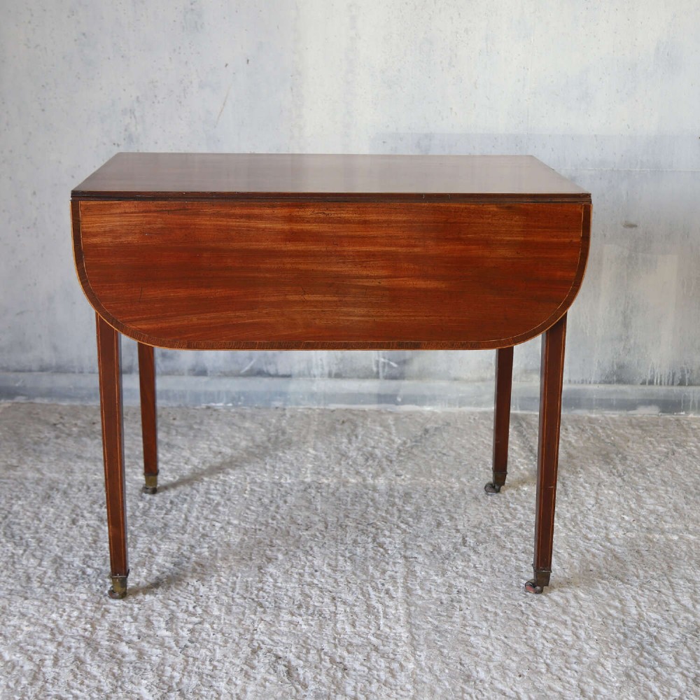 A late 18th-century Sheraton style mahogany Pembroke table with drop leaves, a single drawer, partridge wood crossbanding, and tapered legs on brass castors. View III