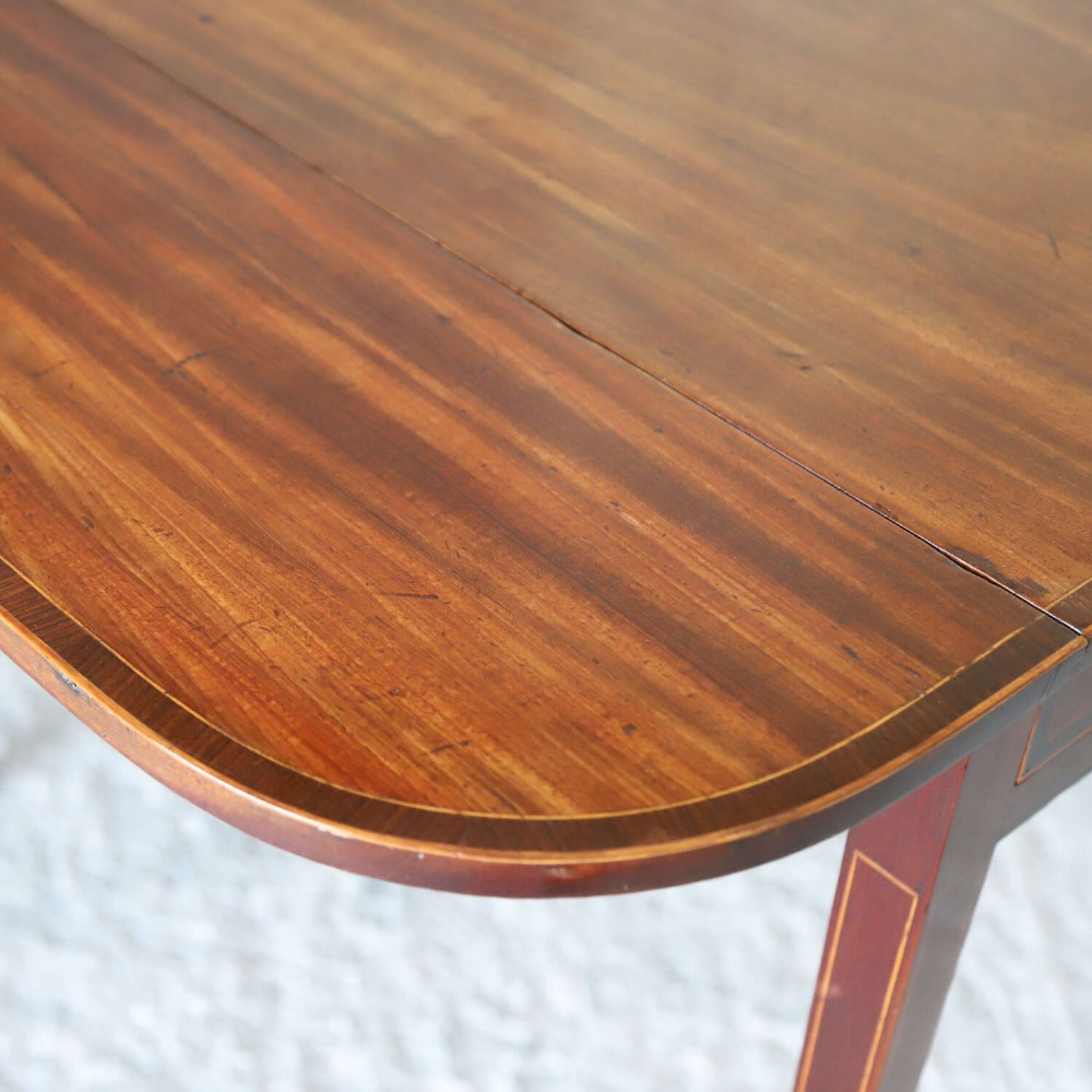 A late 18th-century Sheraton style mahogany Pembroke table with drop leaves, a single drawer, partridge wood crossbanding, and tapered legs on brass castors. View XIII