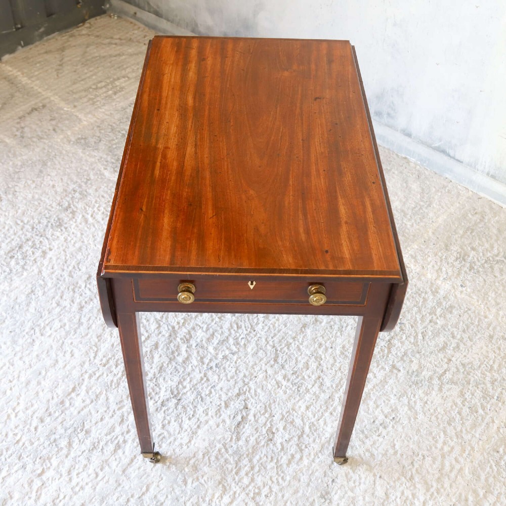 A late 18th-century Sheraton style mahogany Pembroke table with drop leaves, a single drawer, partridge wood crossbanding, and tapered legs on brass castors. View XIV