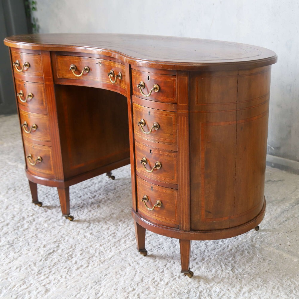 A late eighteenth-century Sheraton Revival mahogany kidney-shaped writing desk featuring a gilt-tooled leather top, nine drawers with brass handles, and line inlay. View III