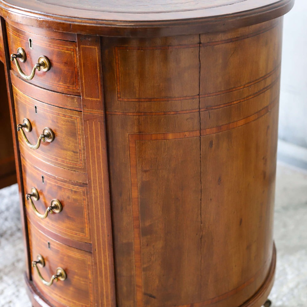 A late eighteenth-century Sheraton Revival mahogany kidney-shaped writing desk featuring a gilt-tooled leather top, nine drawers with brass handles, and line inlay. View IV