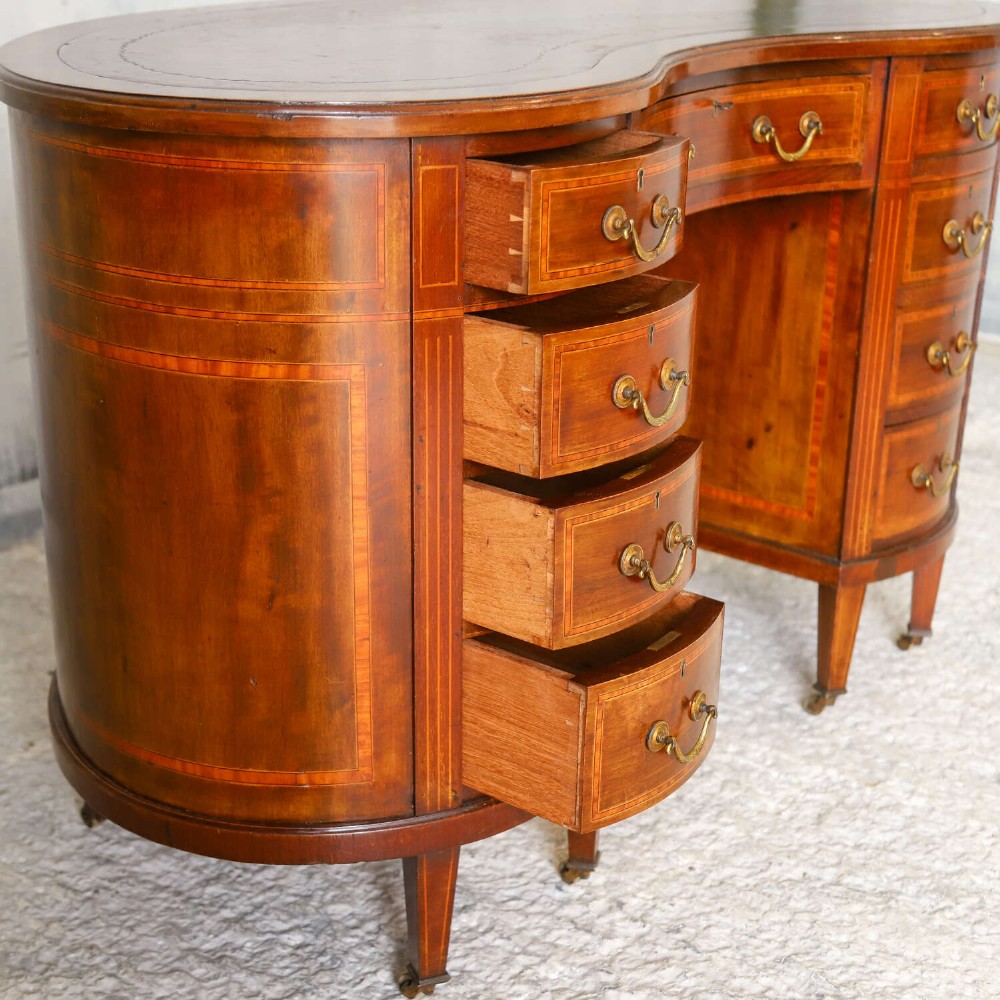 A late eighteenth-century Sheraton Revival mahogany kidney-shaped writing desk featuring a gilt-tooled leather top, nine drawers with brass handles, and line inlay. View VIII