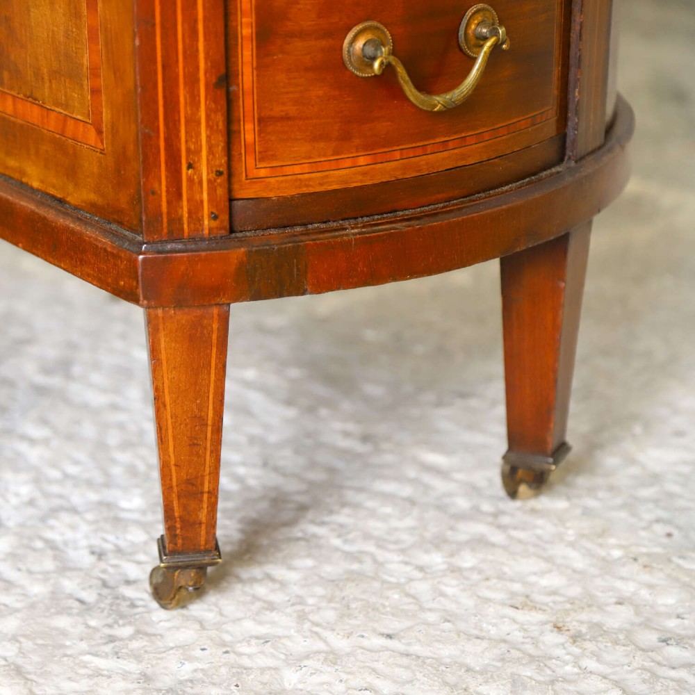A late eighteenth-century Sheraton Revival mahogany kidney-shaped writing desk featuring a gilt-tooled leather top, nine drawers with brass handles, and line inlay. View IX