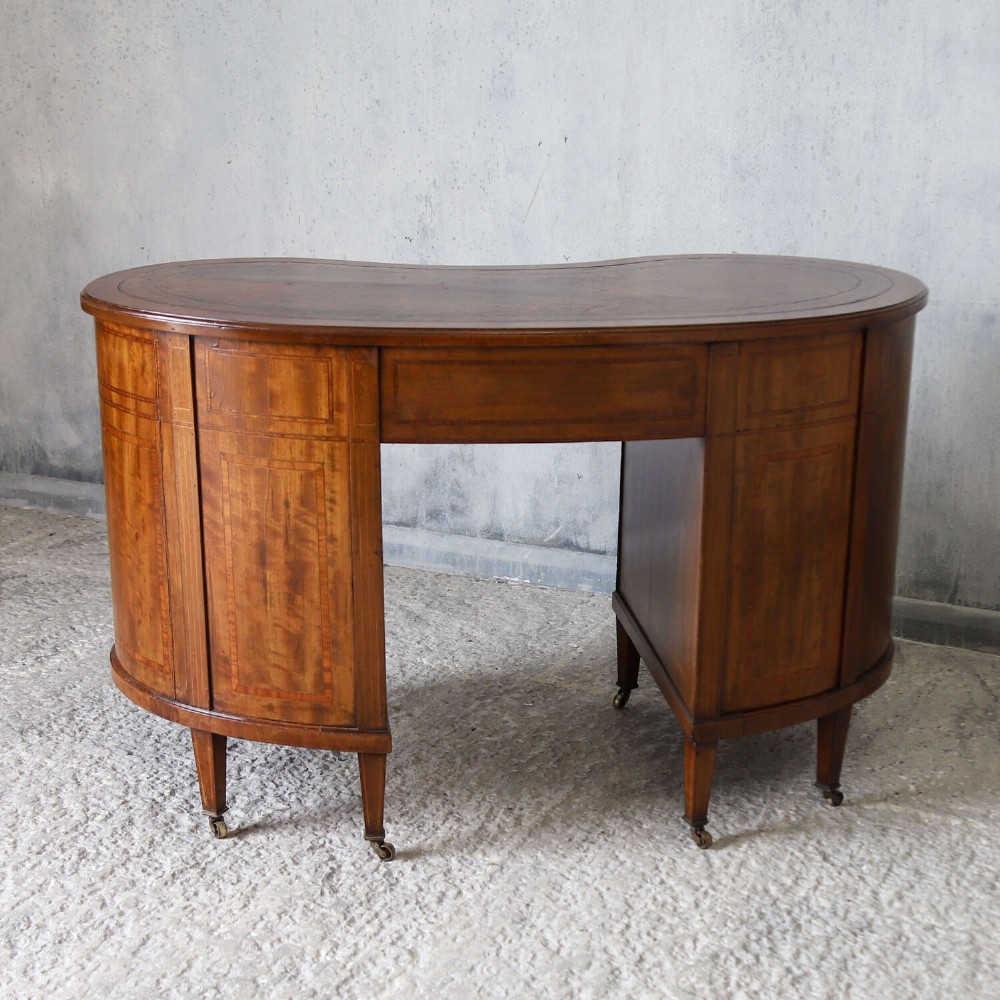 A late eighteenth-century Sheraton Revival mahogany kidney-shaped writing desk featuring a gilt-tooled leather top, nine drawers with brass handles, and line inlay. View XII