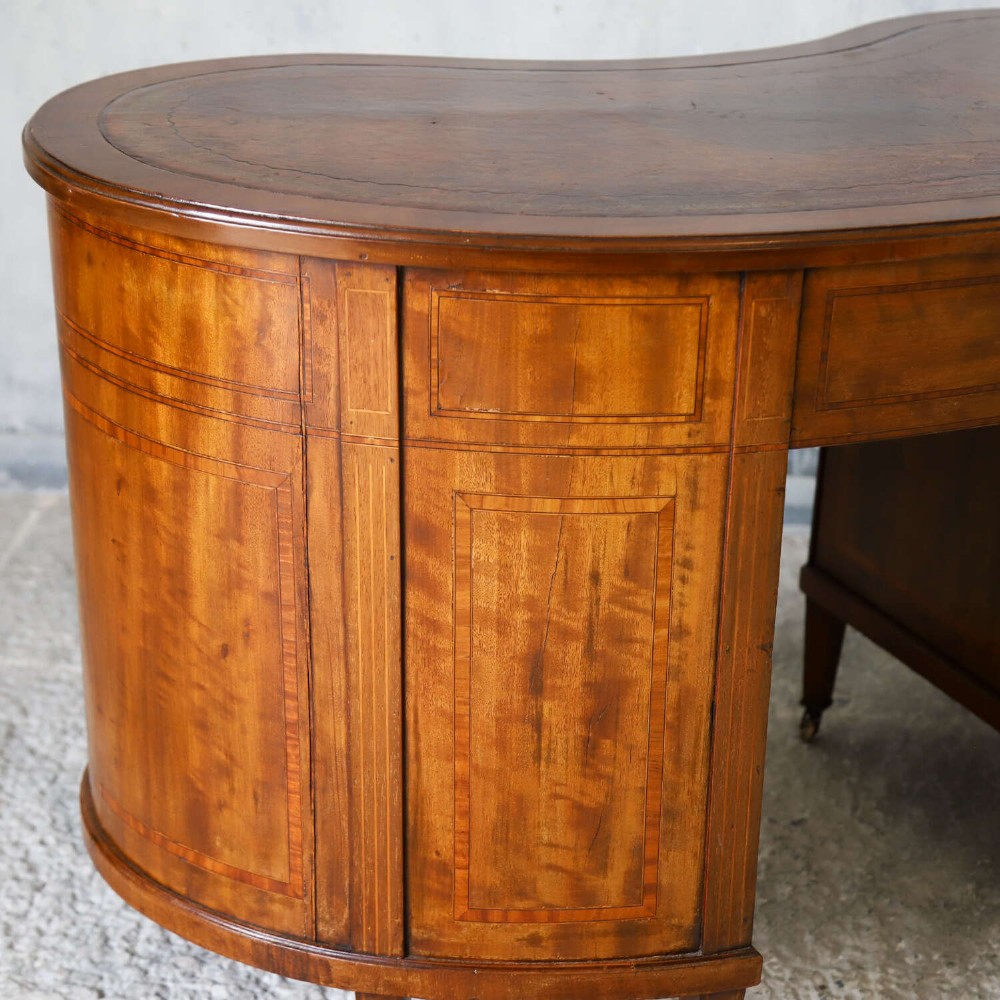 A late eighteenth-century Sheraton Revival mahogany kidney-shaped writing desk featuring a gilt-tooled leather top, nine drawers with brass handles, and line inlay. View XIII