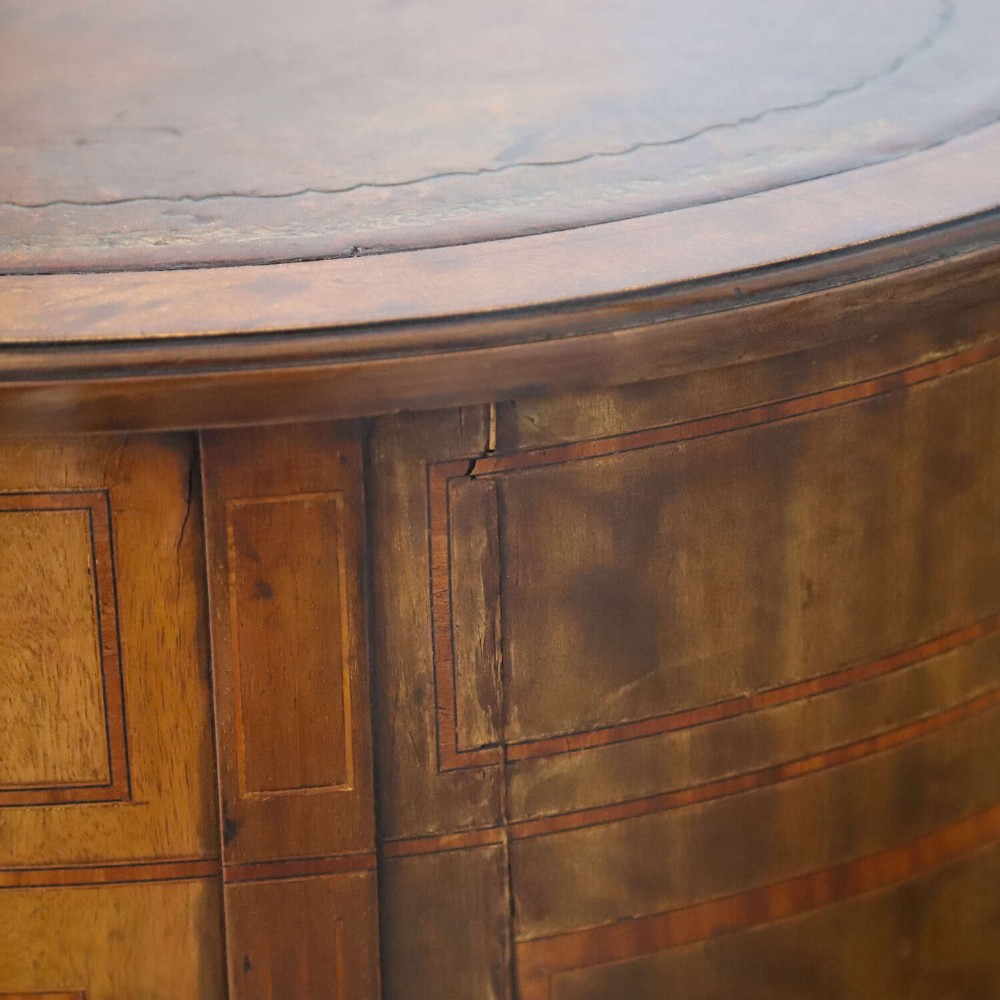 A late eighteenth-century Sheraton Revival mahogany kidney-shaped writing desk featuring a gilt-tooled leather top, nine drawers with brass handles, and line inlay. View XV