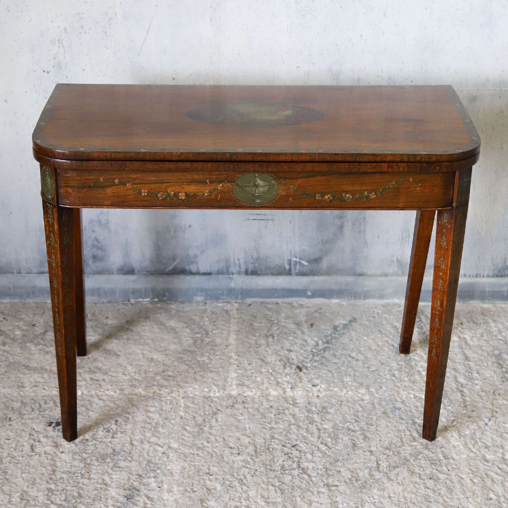 A Regency rosewood card table with a fold-over top, tapered legs, and hand-painted floral garland decoration along the apron. View II