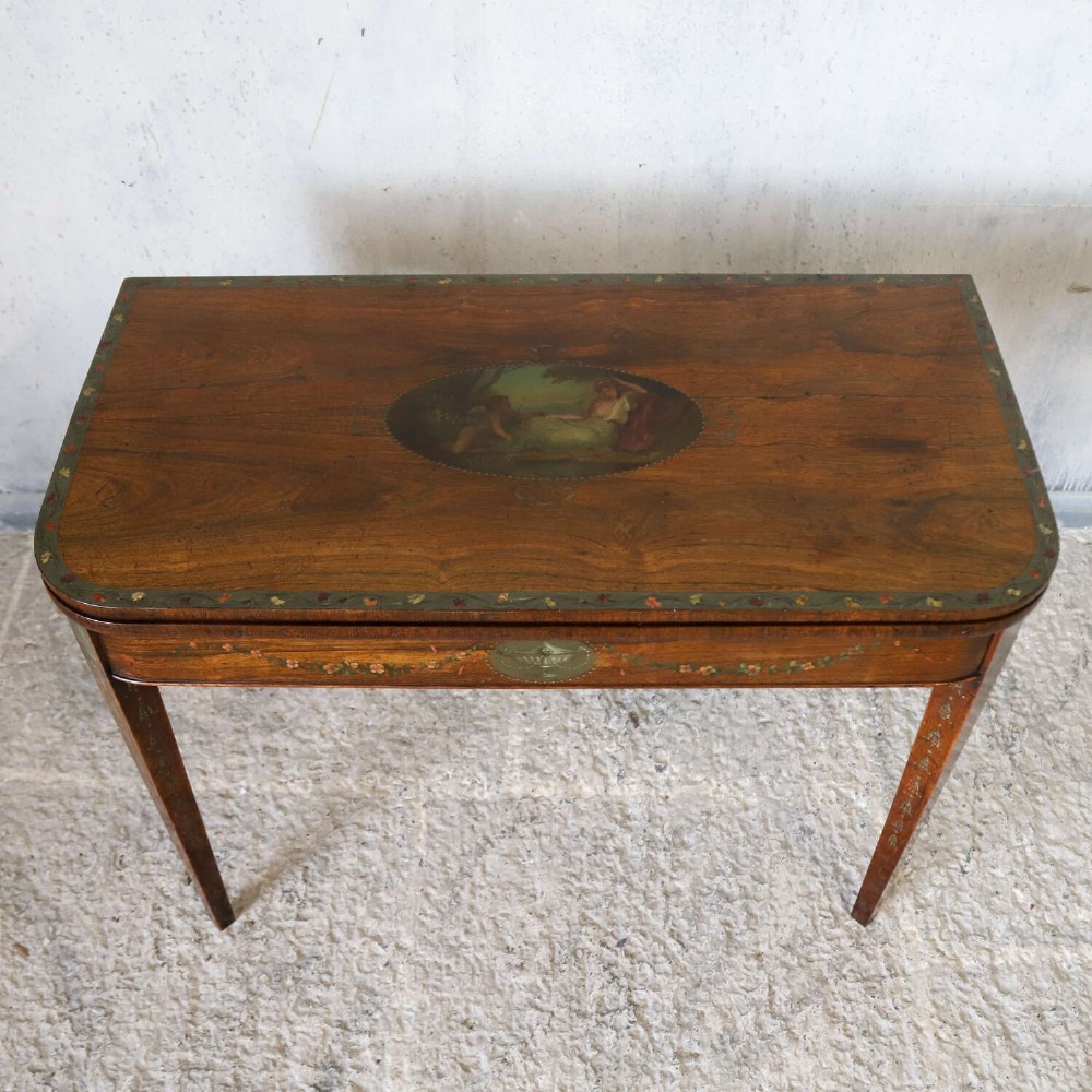 A Regency rosewood card table with a fold-over top, tapered legs, and hand-painted floral garland decoration along the apron. View III