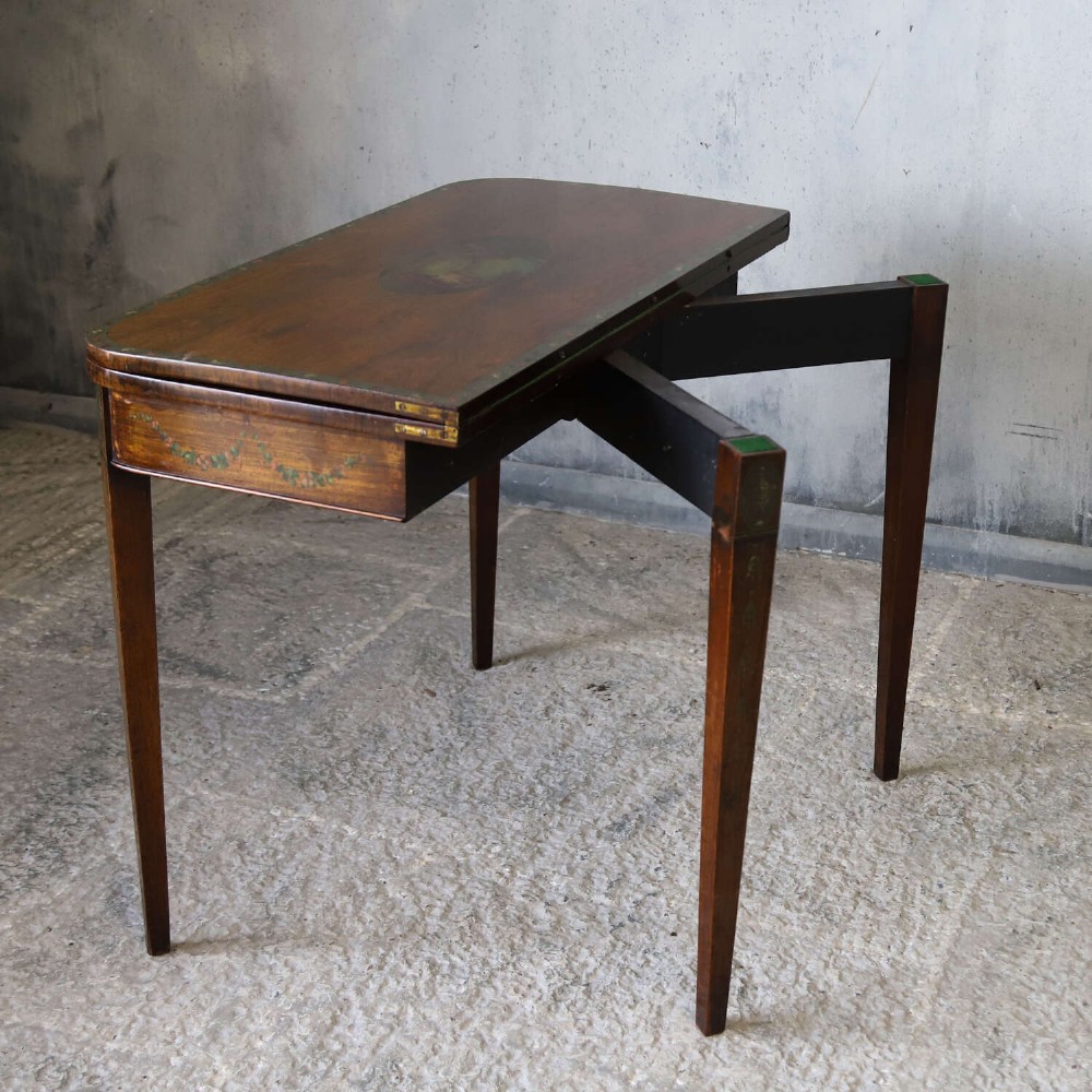 A Regency rosewood card table with a fold-over top, tapered legs, and hand-painted floral garland decoration along the apron. View X