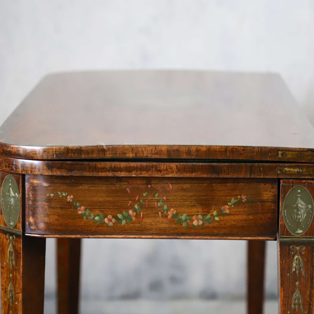 A Regency rosewood card table with a fold-over top, tapered legs, and hand-painted floral garland decoration along the apron. View XII
