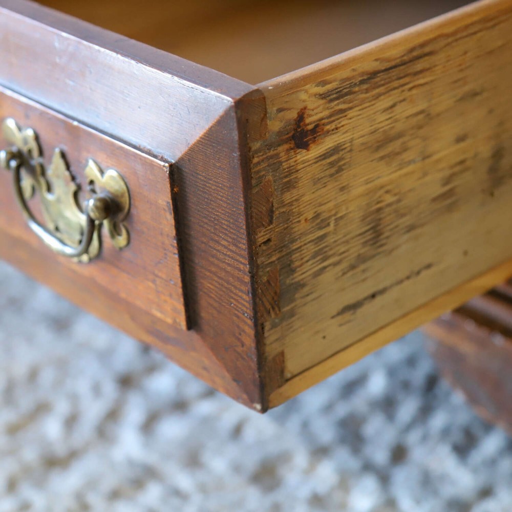 An 18th-century pine mule chest with two raised front panels, two lower drawers, and original brass hardware on a bracket base. View XIV