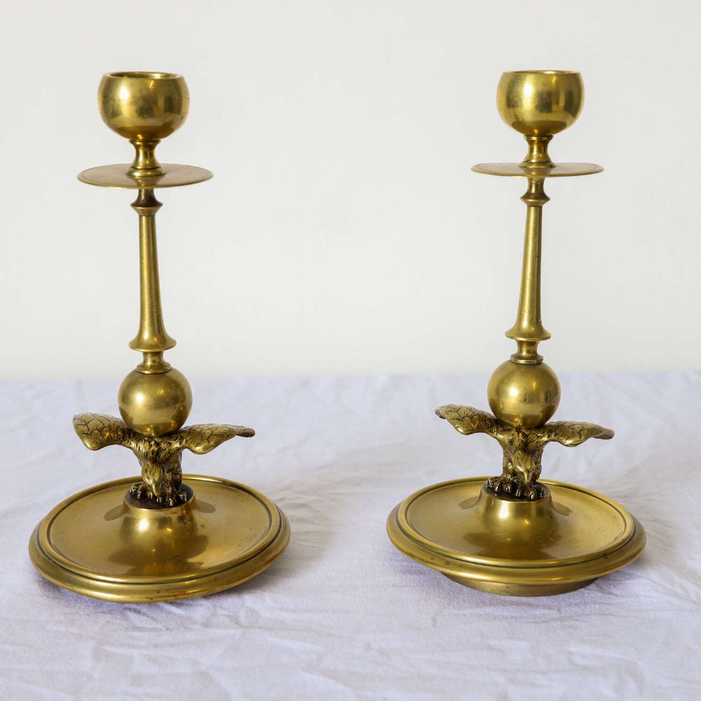 A pair of Georgian brass candlesticks featuring spread-winged eagle motifs supporting tapering stems above circular dished bases. View III