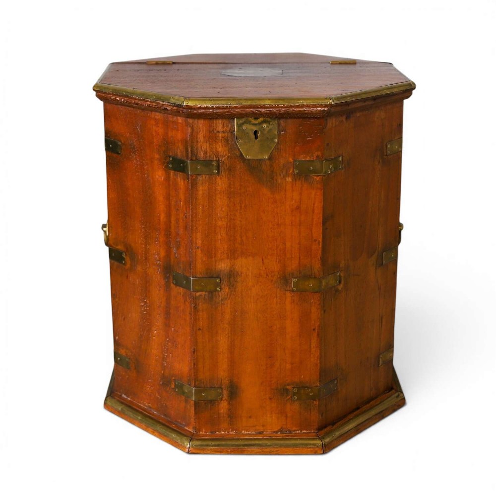An octagonal antique wooden campaign chest featuring a hinged lift-up top, brass corner brackets, strapwork, and side carrying handles against a white background.