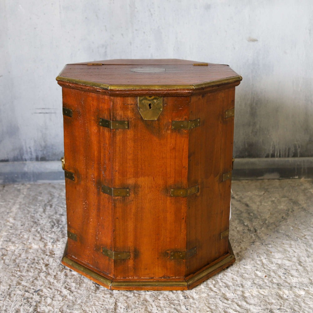 An octagonal antique wooden campaign chest featuring a hinged lift-up top, brass corner brackets, strapwork, and side carrying handles against a white background. View IV