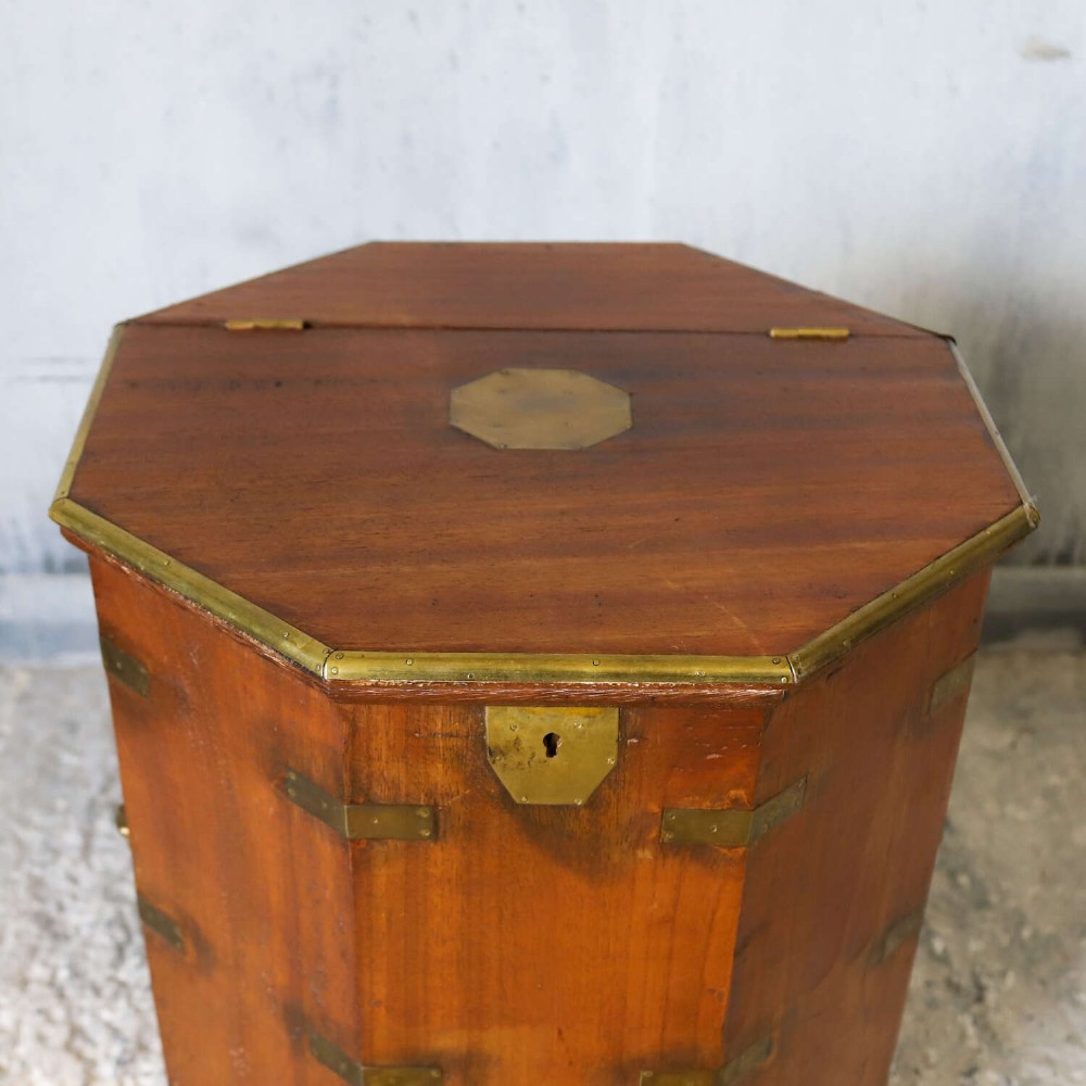 An octagonal antique wooden campaign chest featuring a hinged lift-up top, brass corner brackets, strapwork, and side carrying handles against a white background. View V