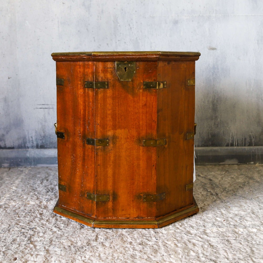 An octagonal antique wooden campaign chest featuring a hinged lift-up top, brass corner brackets, strapwork, and side carrying handles against a white background. View VI