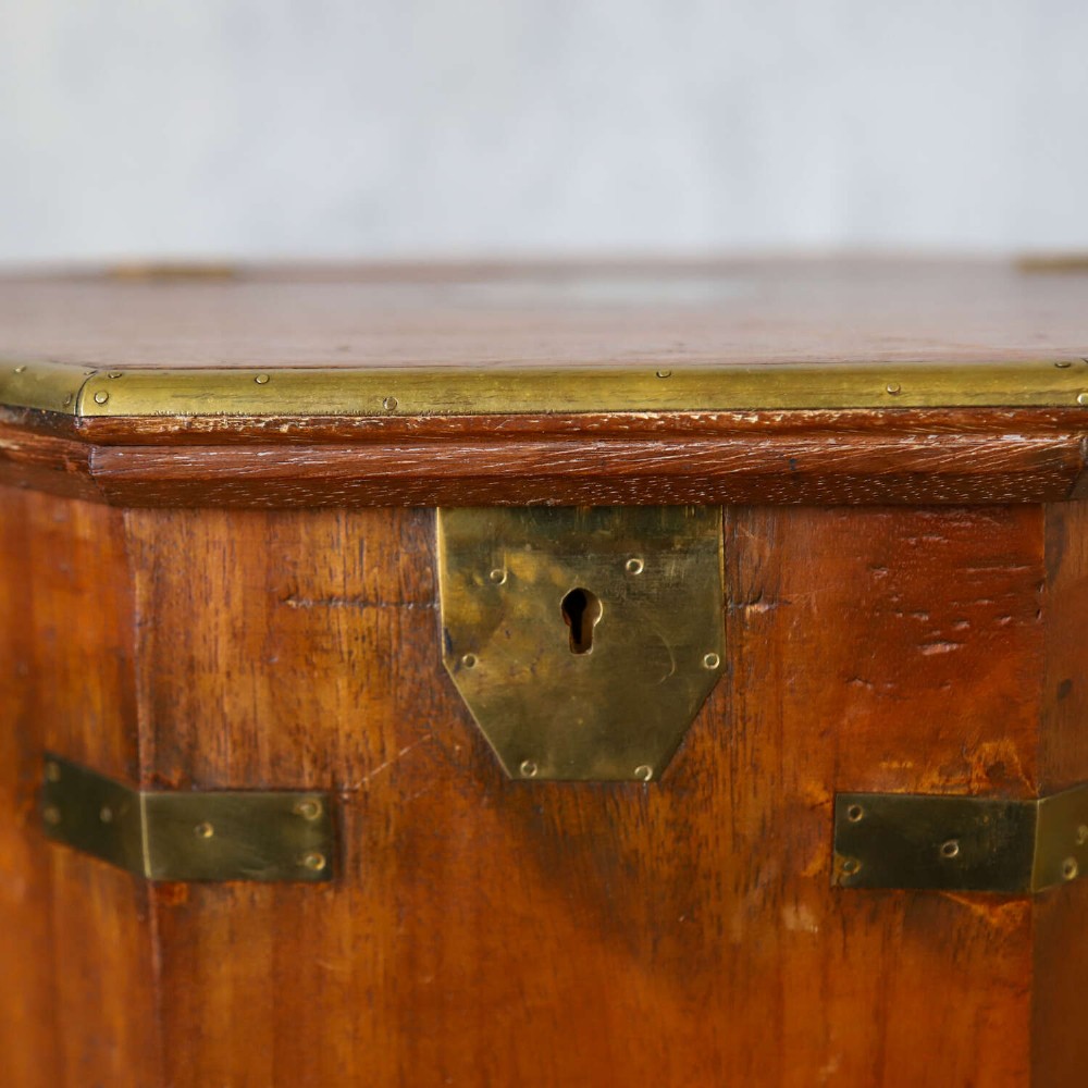 An octagonal antique wooden campaign chest featuring a hinged lift-up top, brass corner brackets, strapwork, and side carrying handles against a white background. View VII