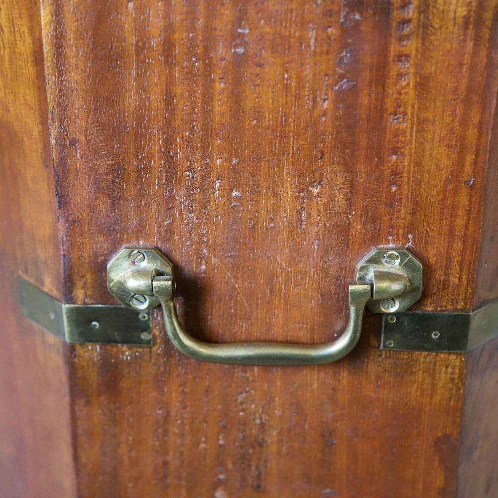 An octagonal antique wooden campaign chest featuring a hinged lift-up top, brass corner brackets, strapwork, and side carrying handles against a white background. View IX