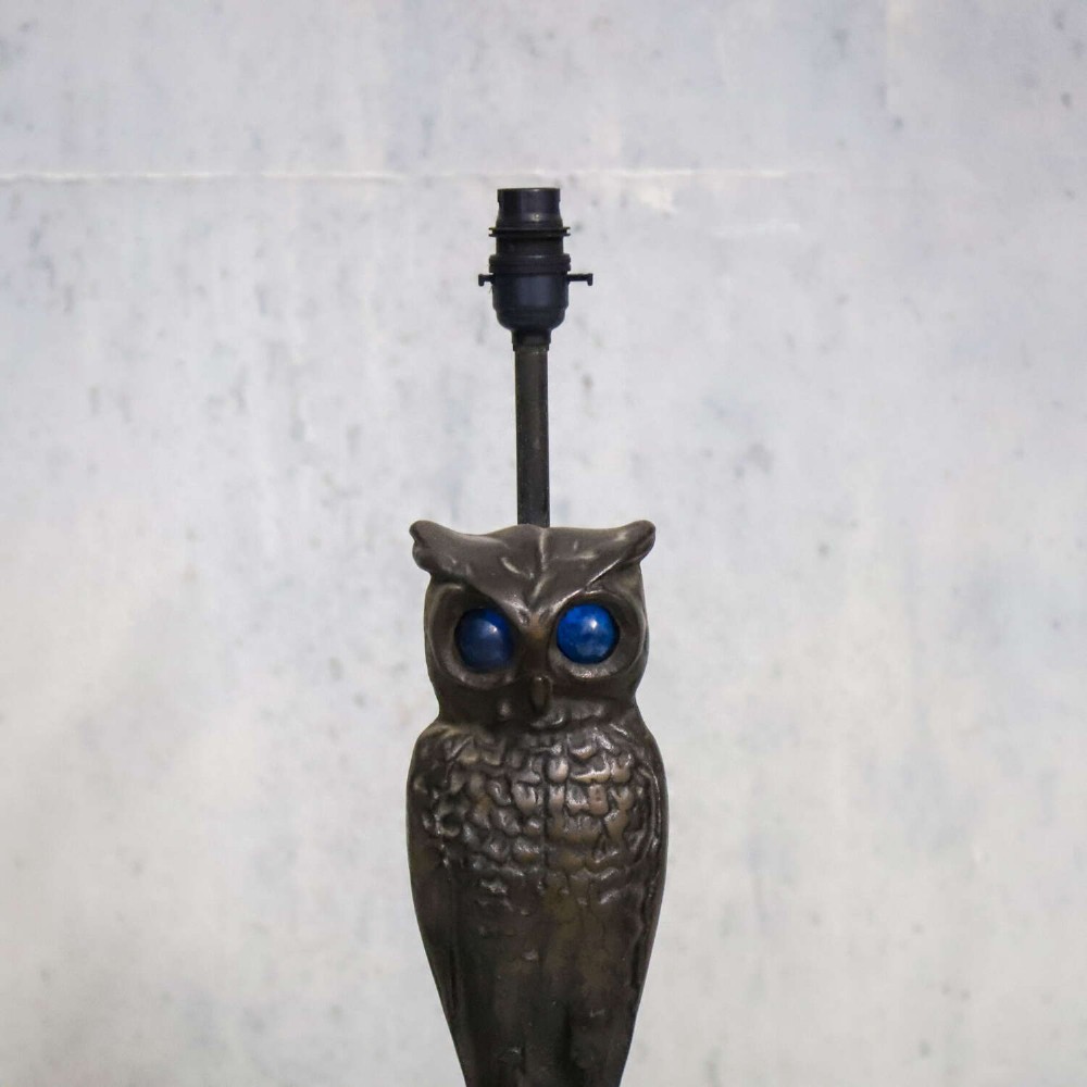 A pair of dark cast iron owl table lamps with bright blue glass eyes, perched on branch bases mounted on black plinths. View III