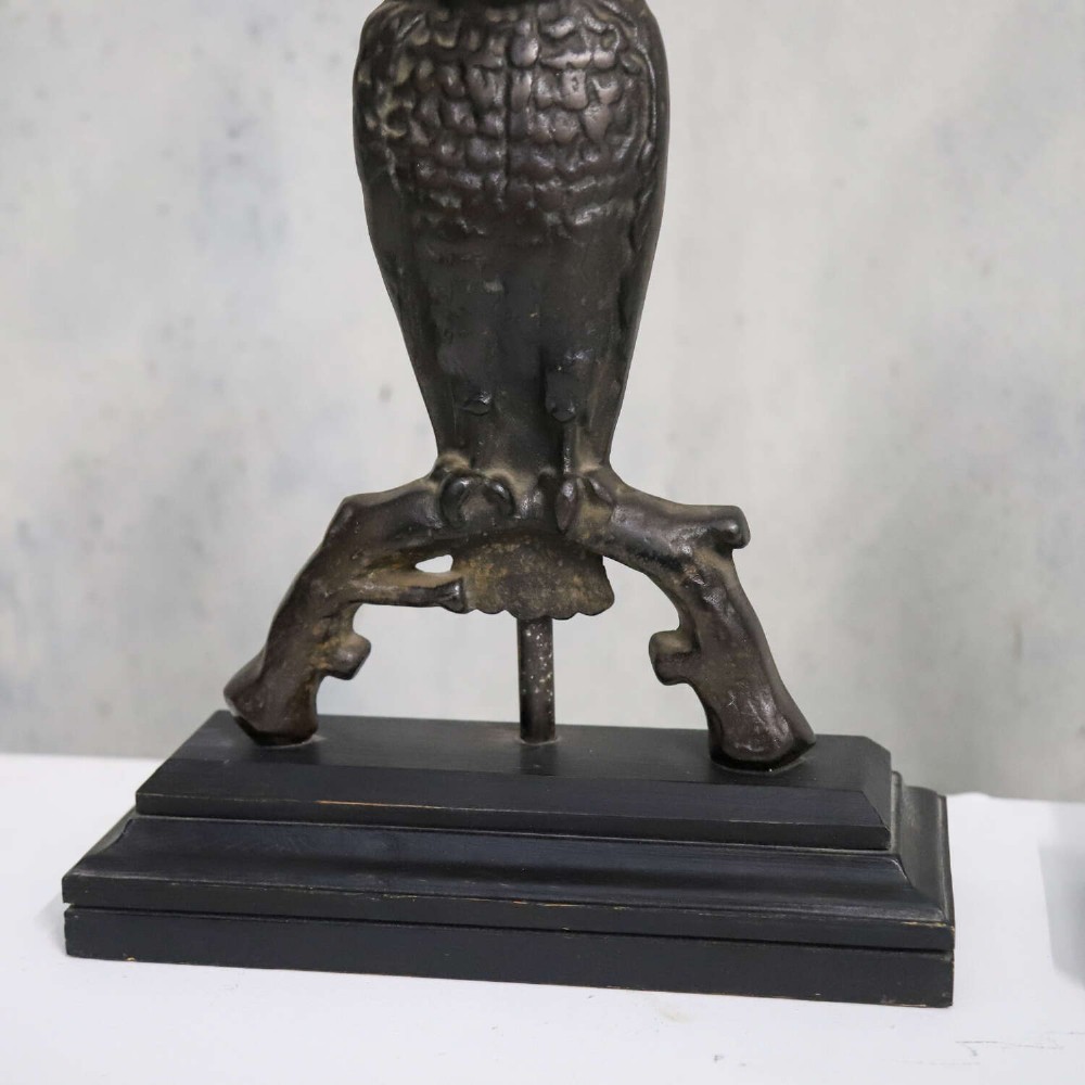 A pair of dark cast iron owl table lamps with bright blue glass eyes, perched on branch bases mounted on black plinths. View VI