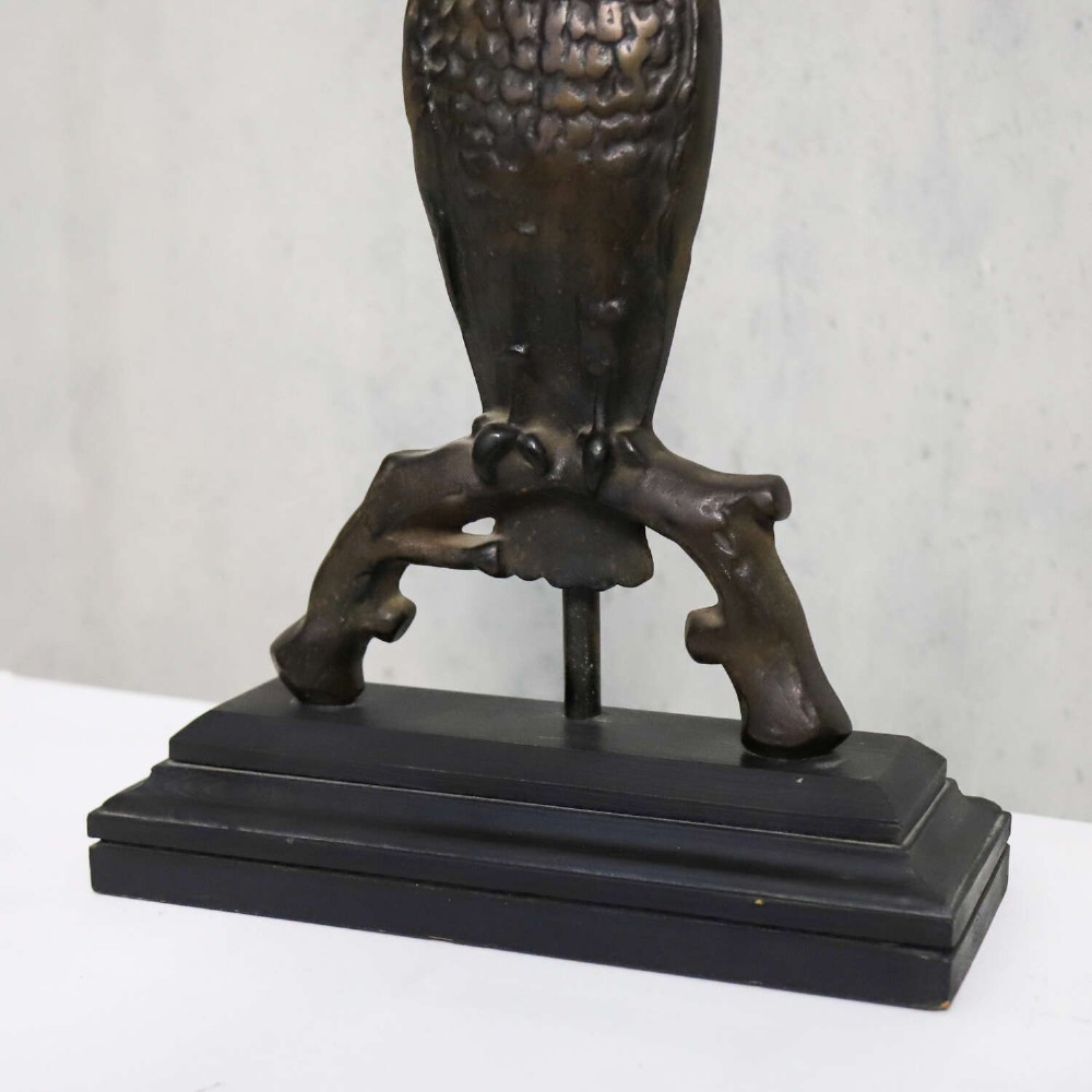 A pair of dark cast iron owl table lamps with bright blue glass eyes, perched on branch bases mounted on black plinths. View X