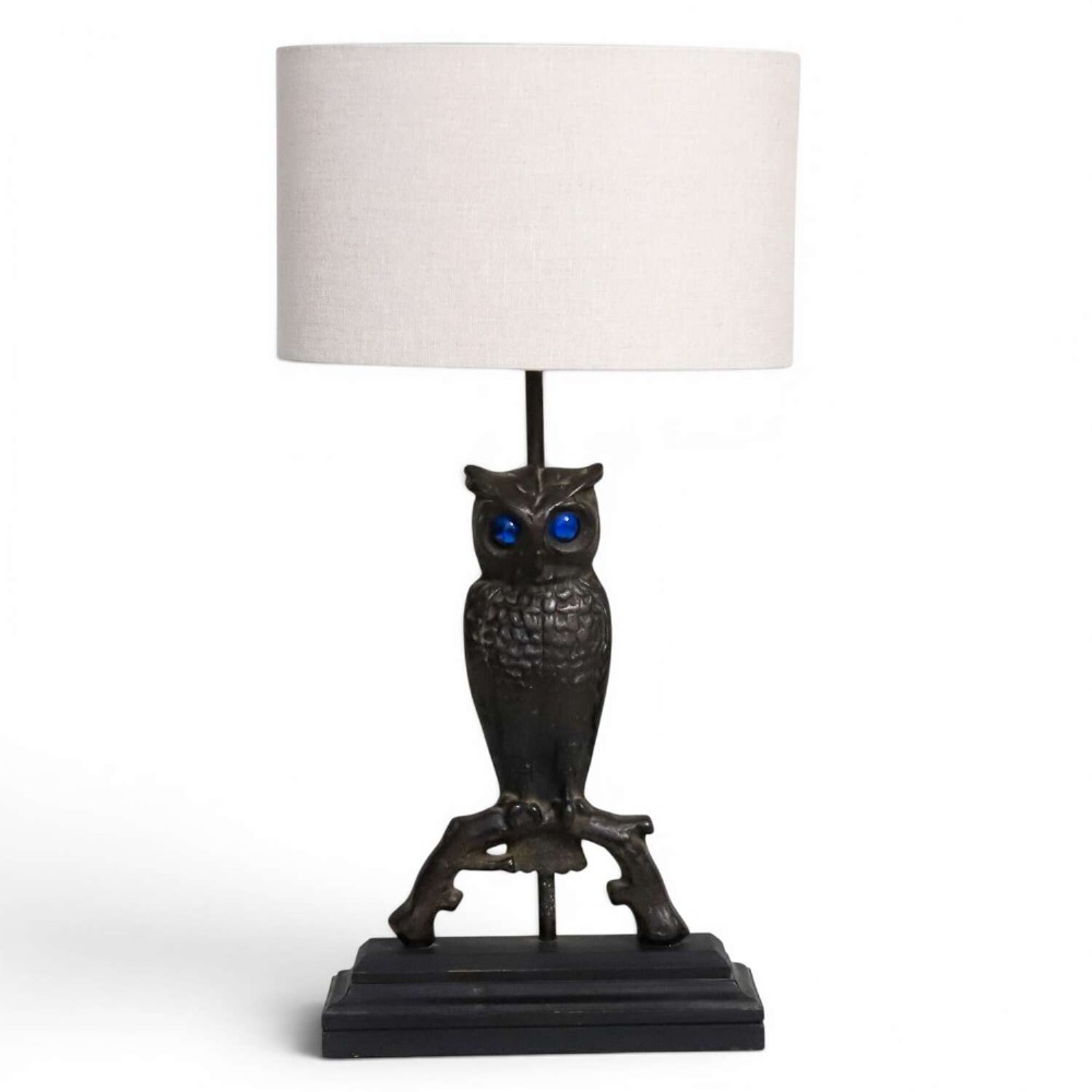 A pair of dark cast iron owl table lamps with bright blue glass eyes, perched on branch bases mounted on black plinths. View XII