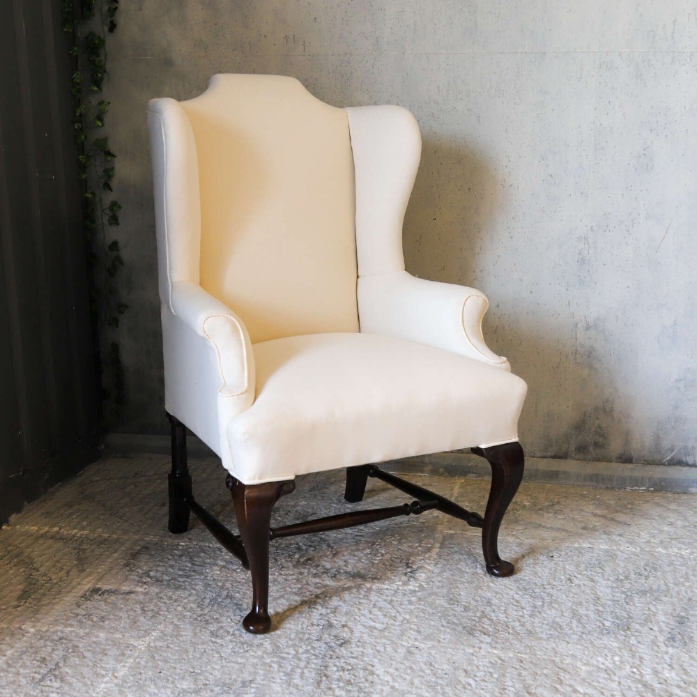 A 19th-century wingback armchair newly upholstered in plain cream calico fabric with dark carved timber cabriole front legs. View III