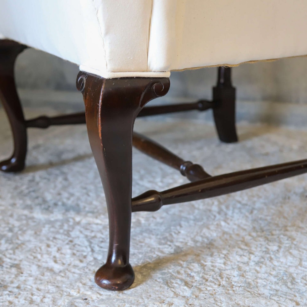 A 19th-century wingback armchair newly upholstered in plain cream calico fabric with dark carved timber cabriole front legs. View VIII