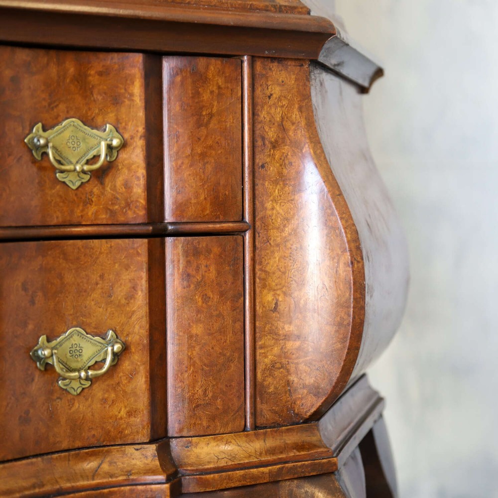 A Dutch walnut-veneered glazed cabinet featuring an arched top, glass paned upper doors, a shaped lower drawer section, and cabriole legs with claw and ball feet. View VI