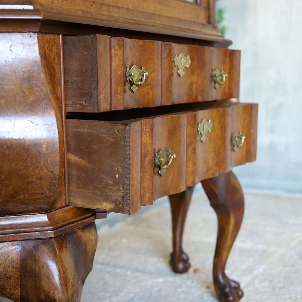 A Dutch walnut-veneered glazed cabinet featuring an arched top, glass paned upper doors, a shaped lower drawer section, and cabriole legs with claw and ball feet. View XI