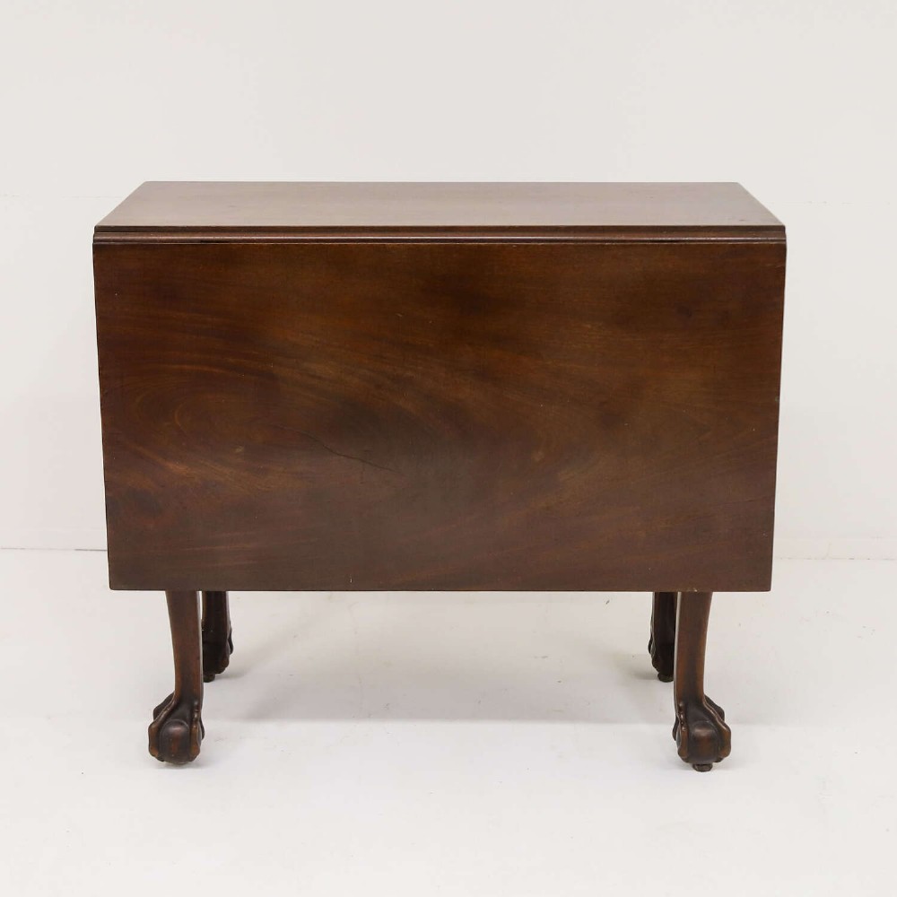 A George II mahogany drop-leaf dining table shown with leaves folded down, supported on four cabriole legs with carved claw-and-ball feet. View II