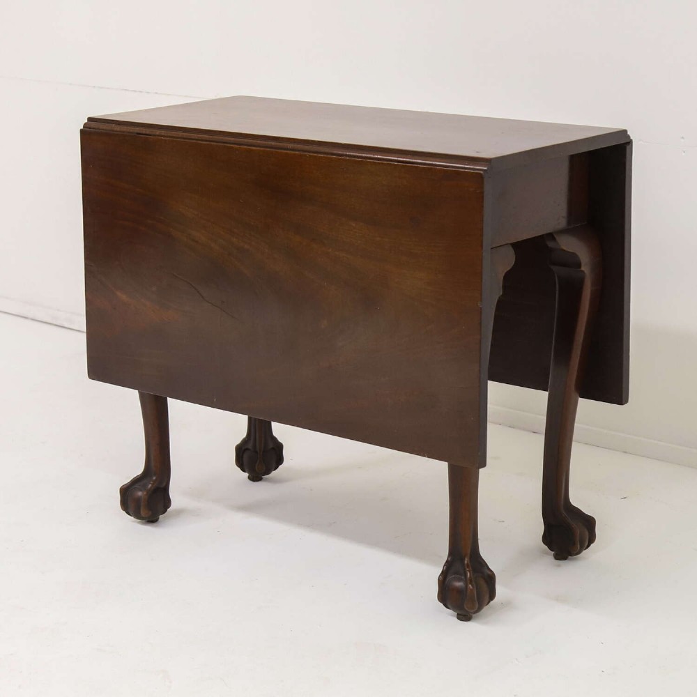 A George II mahogany drop-leaf dining table shown with leaves folded down, supported on four cabriole legs with carved claw-and-ball feet. View III