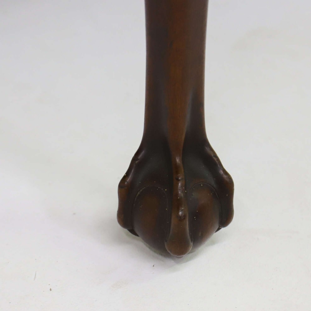A George II mahogany drop-leaf dining table shown with leaves folded down, supported on four cabriole legs with carved claw-and-ball feet. View VI