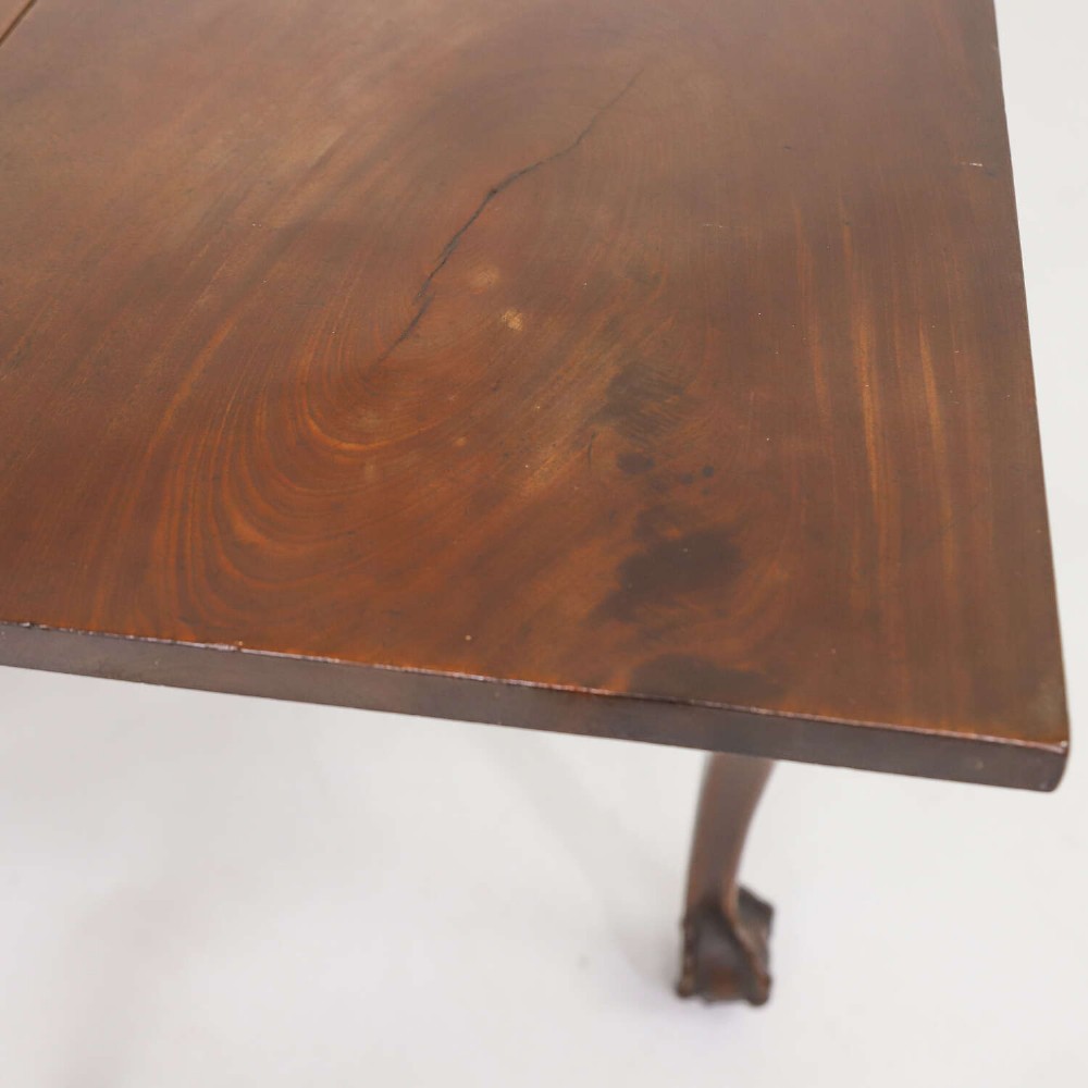 A George II mahogany drop-leaf dining table shown with leaves folded down, supported on four cabriole legs with carved claw-and-ball feet. View VIII