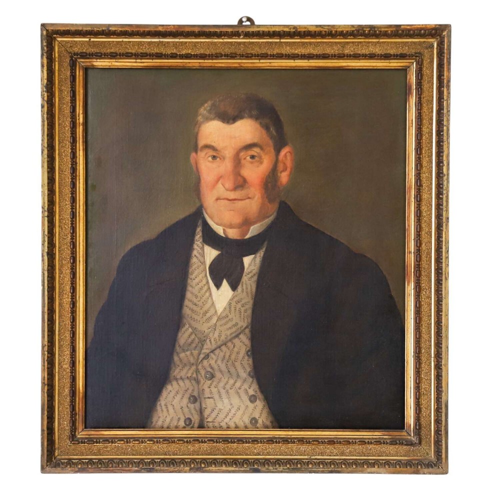 An antique oil painting depicting a male subject wearing a patterned waistcoat and black jacket, set in a gilded frame.