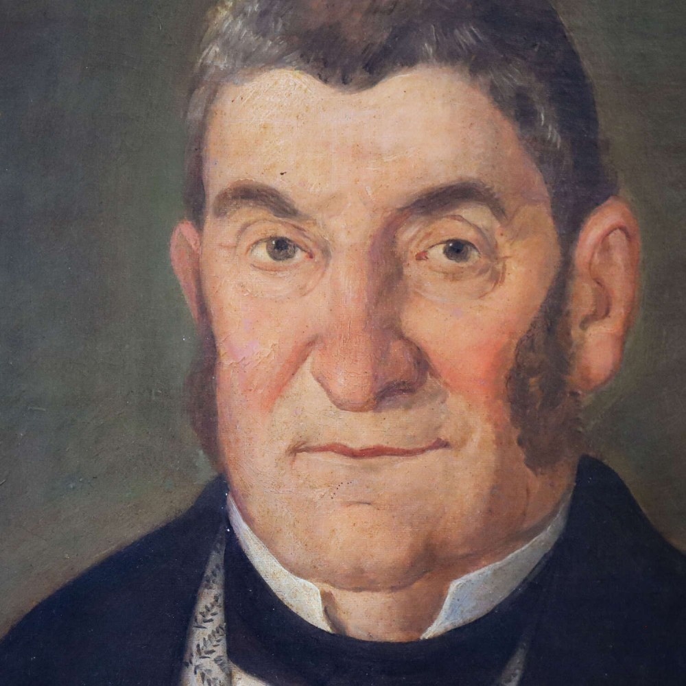 An antique oil painting depicting a male subject wearing a patterned waistcoat and black jacket, set in a gilded frame. View III