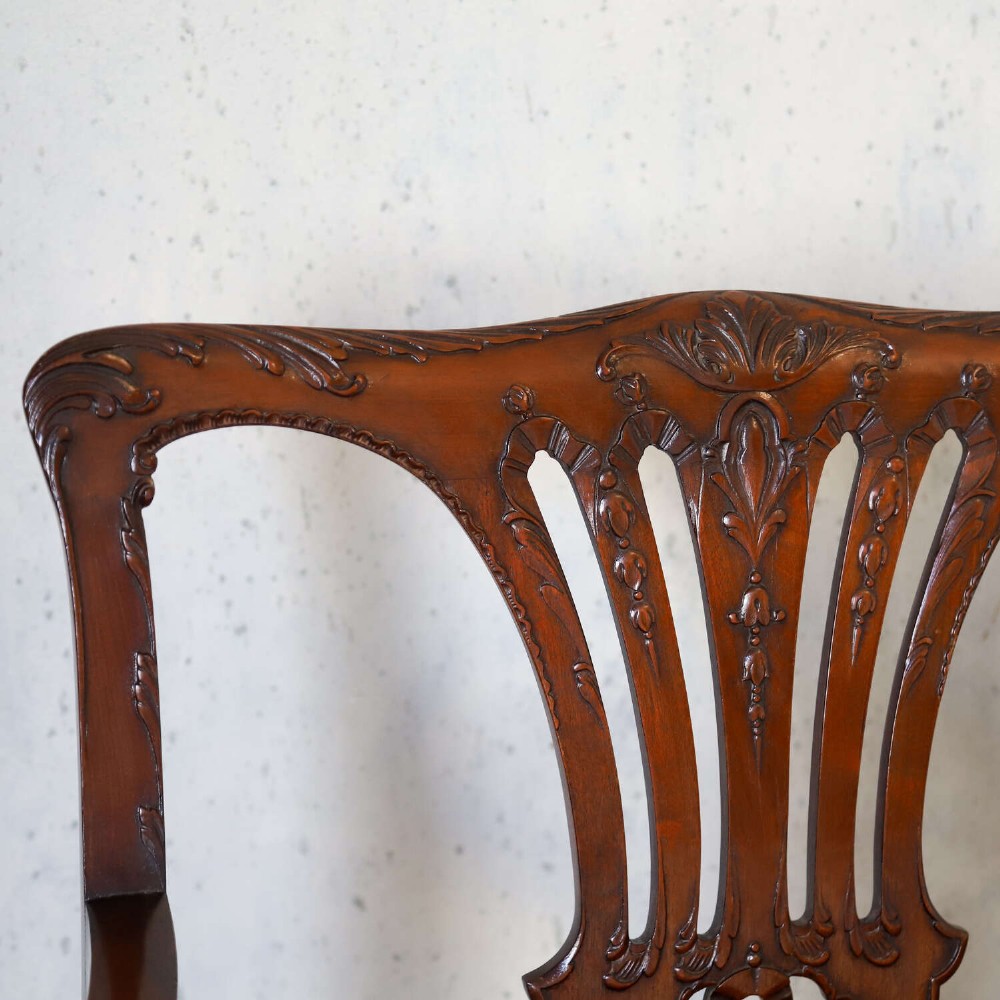 An Edwardian mahogany three-seater settee featuring three carved Chippendale-style pierced back splats, curved armrests, cabriole front legs with ball and claw feet, and a dark upholstered seat. View IV