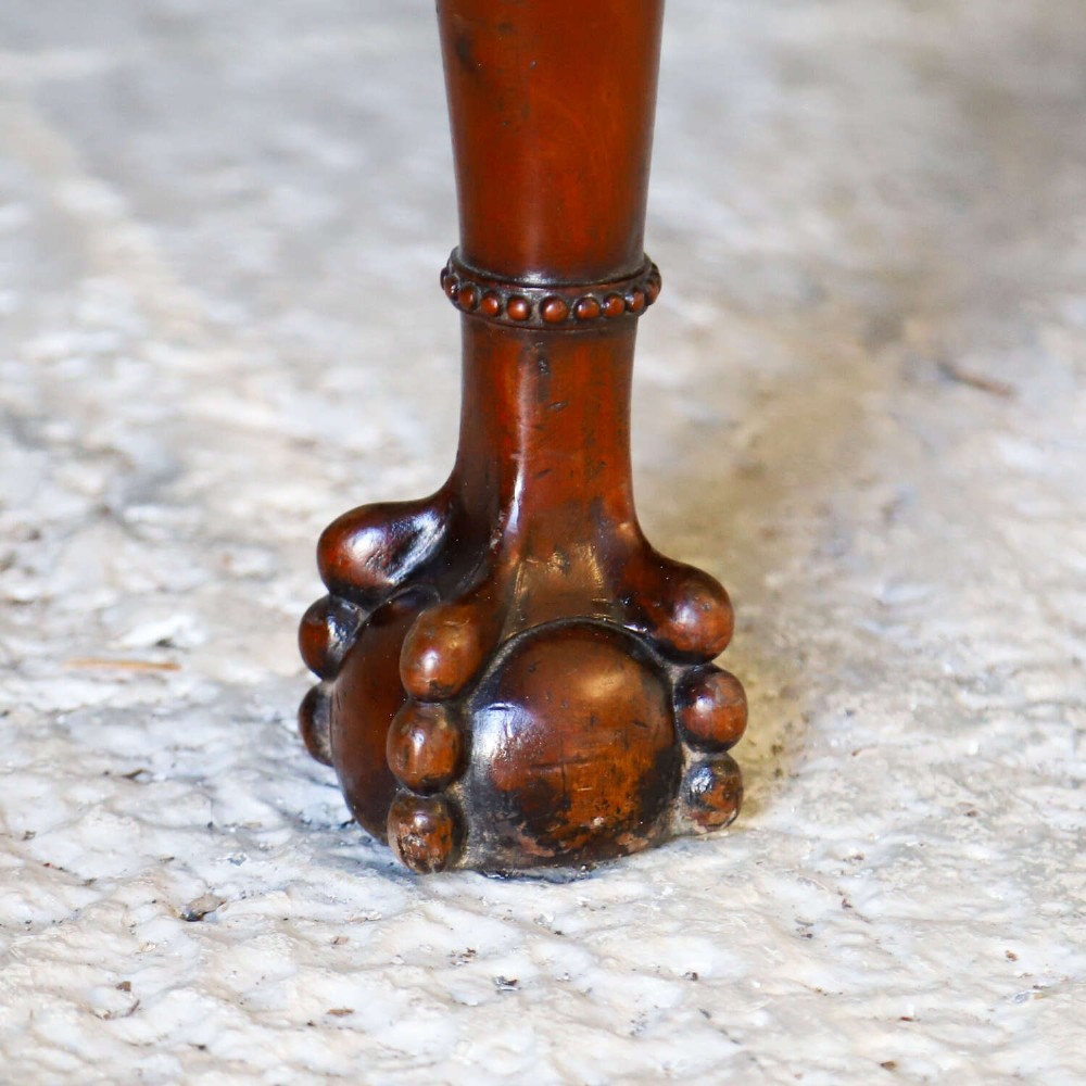 An Edwardian mahogany three-seater settee featuring three carved Chippendale-style pierced back splats, curved armrests, cabriole front legs with ball and claw feet, and a dark upholstered seat. View V