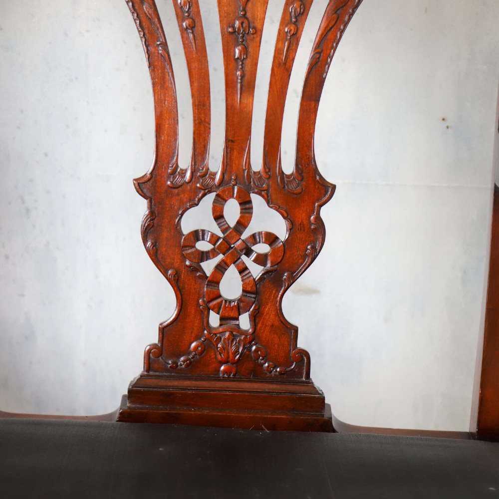An Edwardian mahogany three-seater settee featuring three carved Chippendale-style pierced back splats, curved armrests, cabriole front legs with ball and claw feet, and a dark upholstered seat. View VII