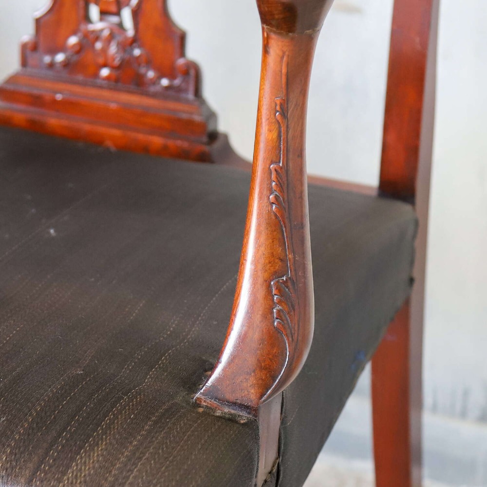 An Edwardian mahogany three-seater settee featuring three carved Chippendale-style pierced back splats, curved armrests, cabriole front legs with ball and claw feet, and a dark upholstered seat. View X