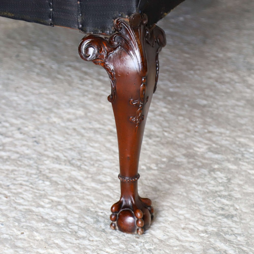 An Edwardian mahogany three-seater settee featuring three carved Chippendale-style pierced back splats, curved armrests, cabriole front legs with ball and claw feet, and a dark upholstered seat. View XII