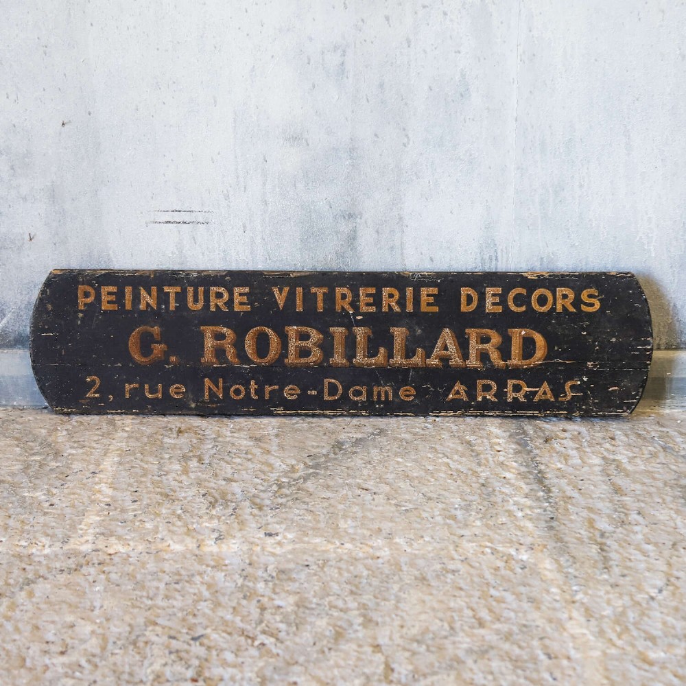 A rectangular black painted timber trade sign featuring gold hand-painted French text reading Peinture Vitrerie Decors G. Robillard Arras. View II