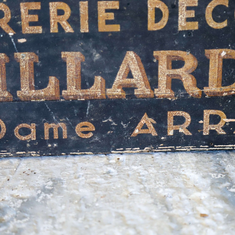 A rectangular black painted timber trade sign featuring gold hand-painted French text reading Peinture Vitrerie Decors G. Robillard Arras. View V