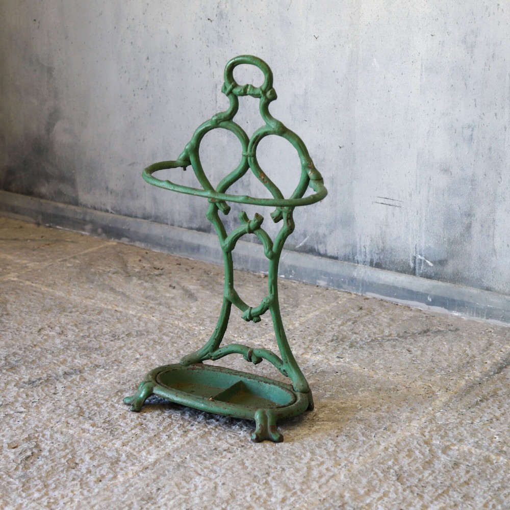 A green painted cast iron umbrella stand featuring a faux bois bamboo framework and an oval drip tray base. View III