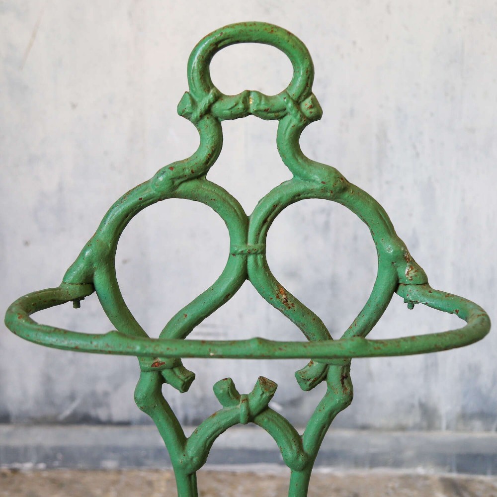 A green painted cast iron umbrella stand featuring a faux bois bamboo framework and an oval drip tray base. View VII