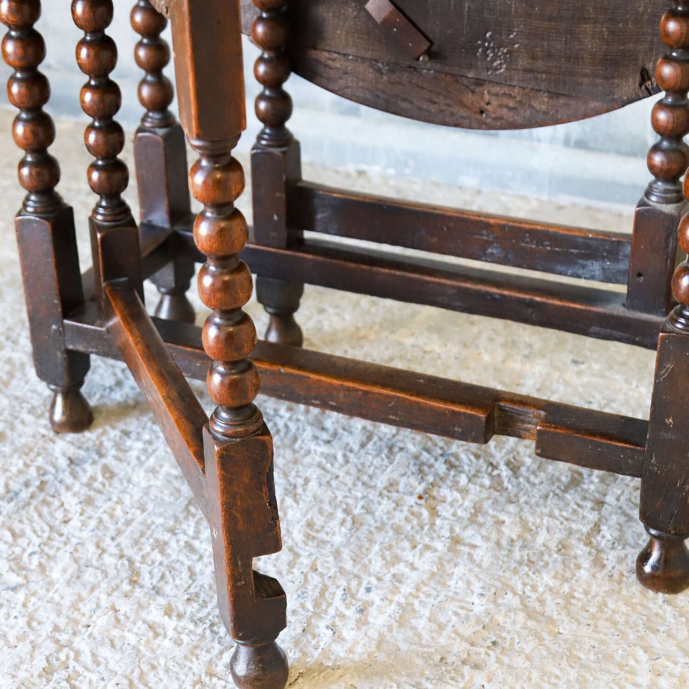 A dark oak gateleg table featuring two hinged drop leaves, bobbin turned legs, and lower box stretchers. View VII