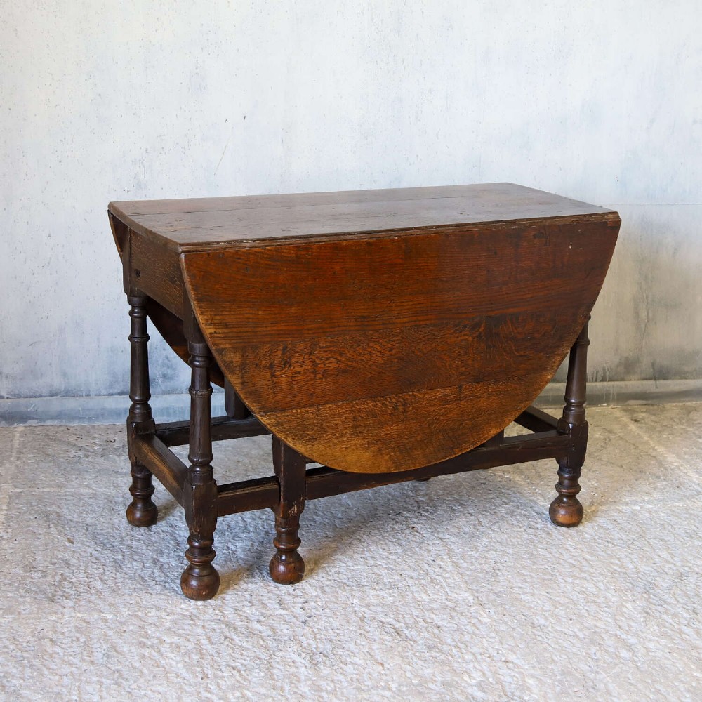 An eighteenth-century oak gateleg drop-leaf table featuring turned legs, lower stretchers, and hinged folding sides. View II