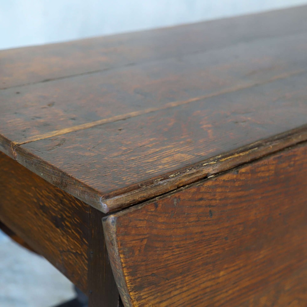 An eighteenth-century oak gateleg drop-leaf table featuring turned legs, lower stretchers, and hinged folding sides. View IV