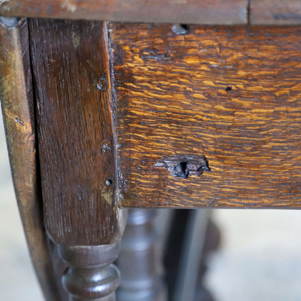 An eighteenth-century oak gateleg drop-leaf table featuring turned legs, lower stretchers, and hinged folding sides. View VI