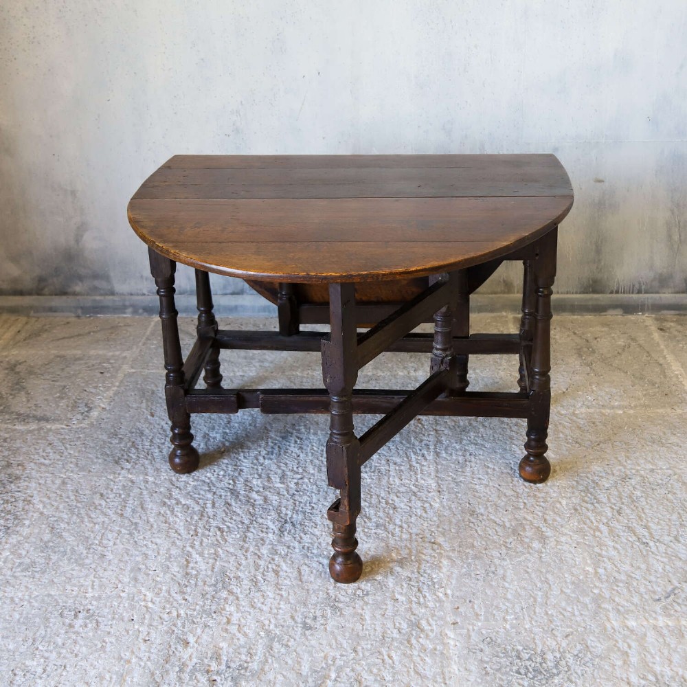 An eighteenth-century oak gateleg drop-leaf table featuring turned legs, lower stretchers, and hinged folding sides. View VIII